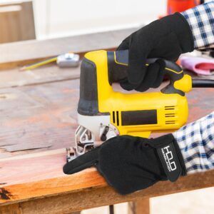 Worker using a jigsaw while wearing black work gloves for hand protection during woodworking